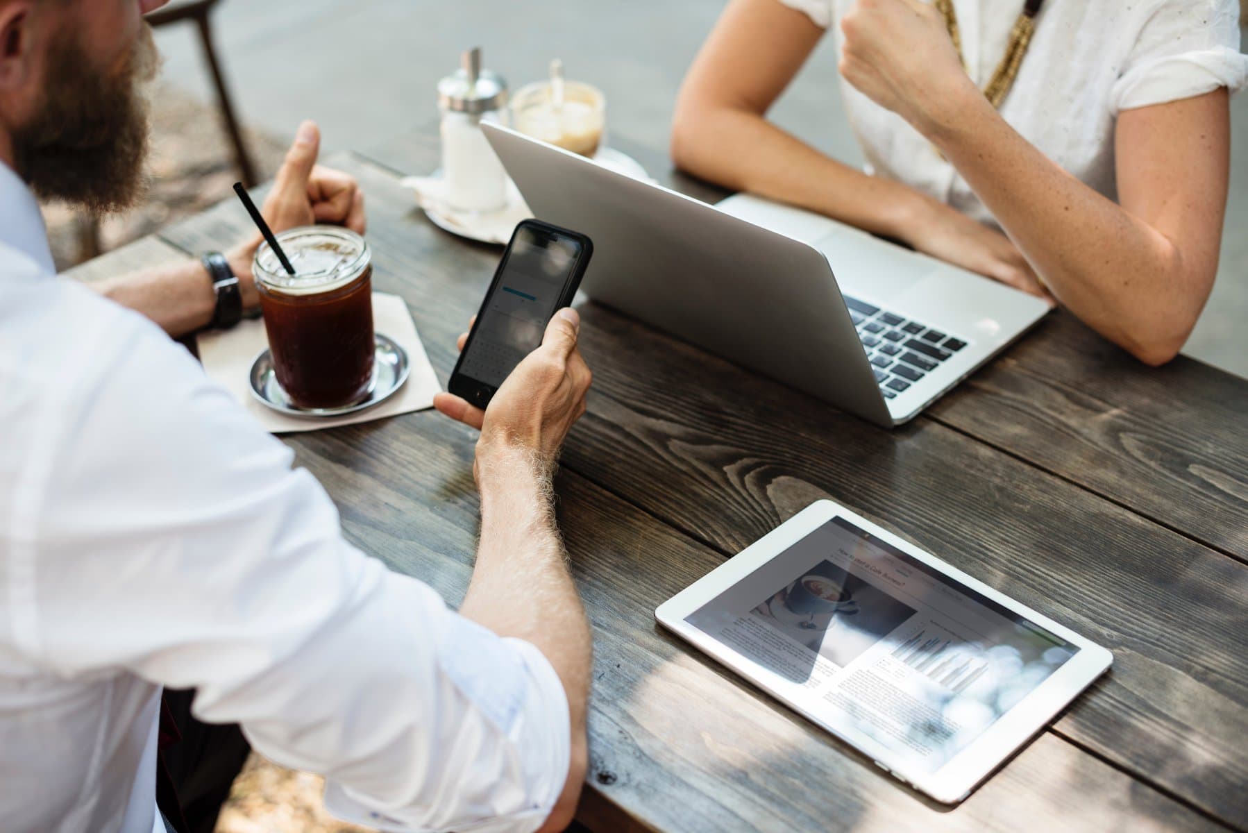 Business meeting between woman with computer and man with coffee